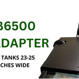 May include: Black XL adapter for tanks 23-25 inches wide. The text "TB6500 XL ADAPTER" is displayed in green. The adapter is part of an aquarium setup, with a clear glass panel and metal components visible.