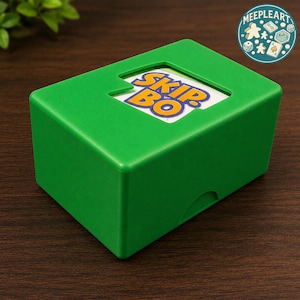 Könnte beinhalten: Eine leuchtend grüne rechteckige Box mit dem Spieltitel "SKIP BO" auf einer Karte in der Mitte. Die Box hat einen kleinen Ausschnitt oben und eine gebogene Vertiefung an der Seite. Ein kreisförmiges Logo mit Spielsymbolen befindet sich in der oberen rechten Ecke.