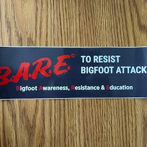 May include: A blue and white sticker with the text "B.A.R.E.® TO RESIST BIGFOOT ATTACKS. Bigfoot Awareness, Resistance & Education" in red and white lettering.