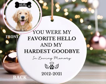 May include: White ceramic bauble with a black paw print and angel wings. The text reads "You were my favourite hello and my hardest goodbye. In loving memory 2012-2021".