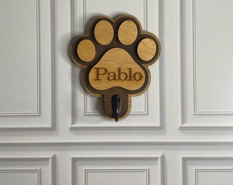 May include: Wooden paw print dog leash hook with the name "Pablo" engraved on it.