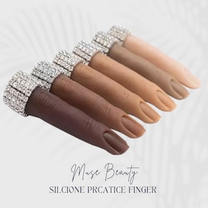 May include: Set of seven silicone practice fingers with different skin tones, each with a ring of rhinestones. The fingers are arranged in a row, with the darkest skin tone on the left and the lightest skin tone on the right. The text "Muse Beauty SILICONE PRCATICE FINGER" is at the bottom of the image.