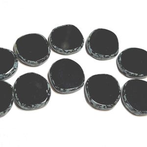 May include: Ten black and white speckled round stones, each with a smooth, polished surface.