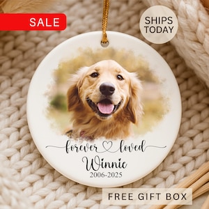 May include: A round, white ceramic ornament featuring a photo of a Golden Retriever dog. The ornament has the text "forever loved Winnie 2006-2025" in black script. A gold string is attached for hanging. The word "SALE" is in a red rectangle.