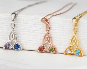 Può includere: Tre collane con nodo celtico in argento, oro rosa e oro con tre pietre preziose ciascuna. Le collane presentano un design a nodo della Trinità con una pietra preziosa viola, blu e rossa sulla collana d'argento, una pietra preziosa rossa, verde e marrone sulla collana in oro rosa e una pietra preziosa rosa, blu e blu chiaro sulla collana in oro.