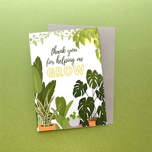 May include: A greeting card with a botanical theme, featuring various green plants and the text "thank you for helping me GROW." The card is white with a gray envelope, set against a green background. The design includes illustrations of potted plants.
