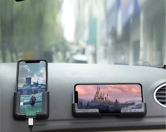 May include: Two black car phone holders with a phone in each. The phones are displaying images of a castle. The phone holders are designed to be placed on the dashboard of a car.