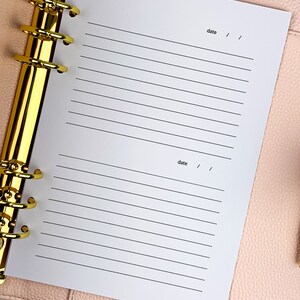 May include: A white page with lined paper in a gold ring binder. The page has the word "date" written at the top and bottom with a space for writing the date.