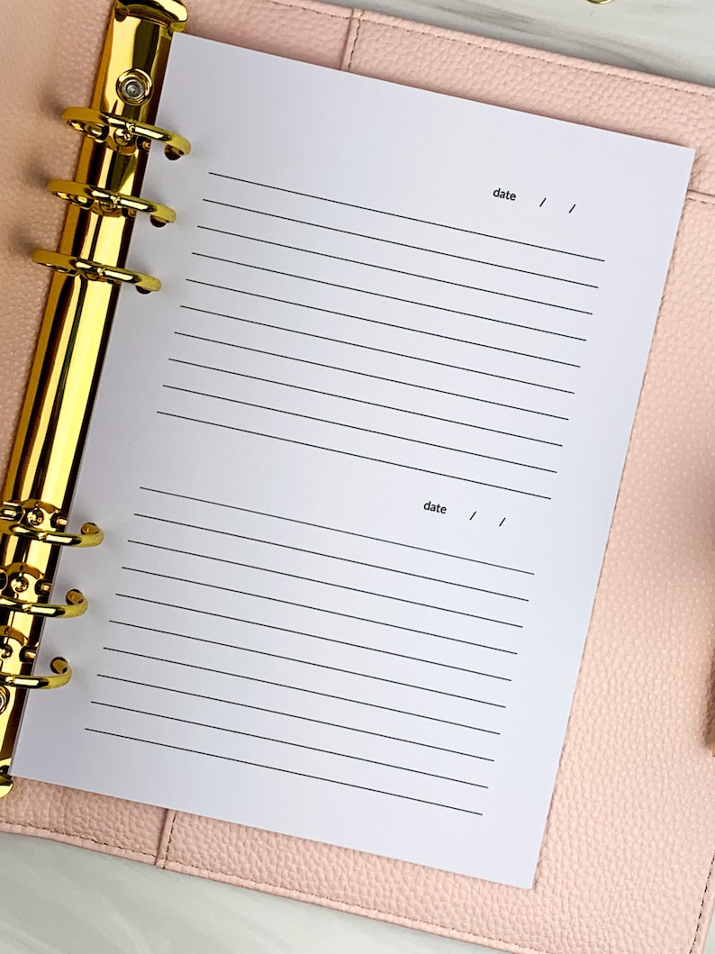 May include: A white page with lined paper in a gold ring binder. The page has the word "date" written at the top and bottom with a space for writing the date.