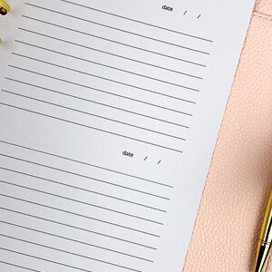 May include: A white planner with lined pages and the word "date" written at the top of each page.