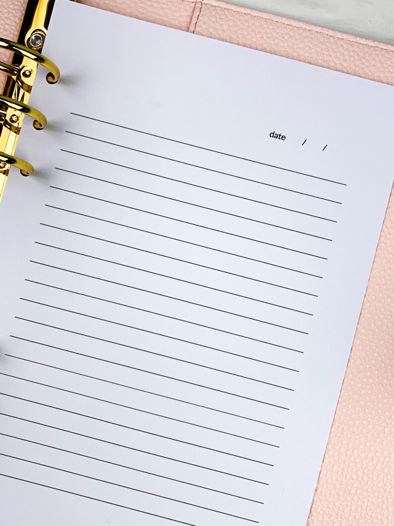 Pu&ograve; includere: Un quaderno bianco a righe con un raccoglitore dorato e la parola "data" scritta in cima alla pagina.