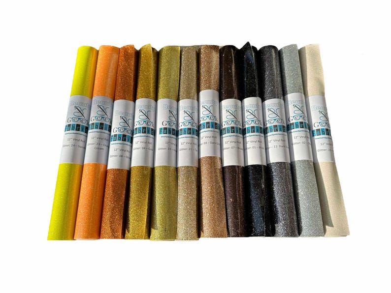 Puede incluir: Doce rollos de tela de vinilo con purpurina de 30,5 cm de largo en varios colores, incluidos amarillo, naranja, dorado, marr&oacute;n, negro, plateado y blanco. Cada rollo tiene una etiqueta con el texto "Wonder & Goodie" y "12" Vinyl Roll.