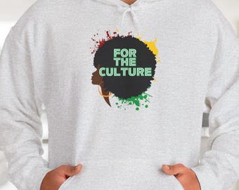 Może przedstawiać: Jasnoszara bluza z kapturem z przednią kieszenią i kapturem ze sznurkiem. Projekt przedstawia czarną sylwetkę afro ze słowami "FOR THE CULTURE" w kolorze zielonym, otoczoną czerwonymi, zielonymi i żółtymi plamami farby.