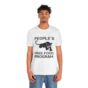 Könnte beinhalten: Weißes T-Shirt mit dem schwarzen Text "PEOPLE'S FREE FOOD PROGRAM". Darunter befindet sich eine schwarze Panther-Grafik. Das T-Shirt hat einen Rundhalsausschnitt und kurze Ärmel.
