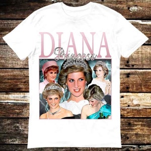 May include: White t-shirt with a pink graphic of Princess Diana. The graphic features a collage of photos of Diana in different outfits and poses. The text "Diana Princess" is printed in pink letters above the collage.