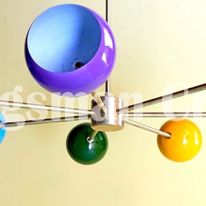 May include: A modern, multi-coloured, six-light chandelier with round, globe-shaped shades in blue, green, yellow, red, and purple.