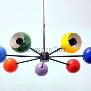 May include: A six-light chandelier with a black metal frame and colorful glass globes. The globes are green, yellow, blue, red, and purple.