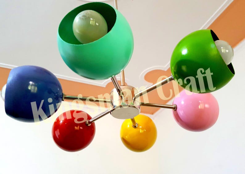 May include: A six-light ceiling fixture with colorful spherical shades. The shades are green, blue, red, yellow, and pink. The fixture has a chrome finish.