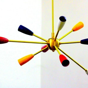 May include: A gold-coloured, multi-armed chandelier with eight colourful glass shades. The shades are red, yellow, white, and blue.