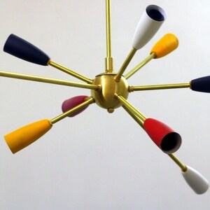 May include: A brass chandelier with eight colourful shades. The shades are red, yellow, blue and white.