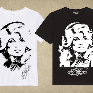 Puede incluir: Dos camisetas, una blanca y otra negra, cada una con un retrato en blanco y negro de una mujer con cabello largo y ondulado. La imagen incluye una firma en la parte inferior. Las camisetas son de manga corta.