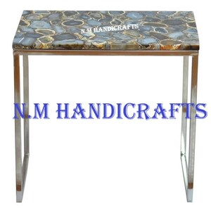 May include: A modern side table with a stainless steel frame and a blue agate stone top. The table is approximately 24 inches wide and 16 inches tall. The agate stone top features a unique pattern of natural blue and brown agate.