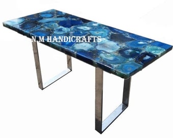 May include: A blue agate table top with a stainless steel base. The table top has a unique pattern of blue and green agate.