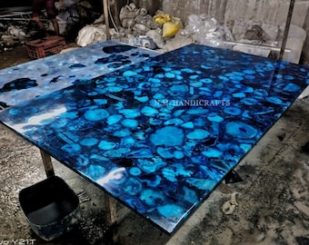May include: A large blue agate slab table top with a polished finish. The table top is made of natural agate stone and features a unique pattern of blue and black agate.