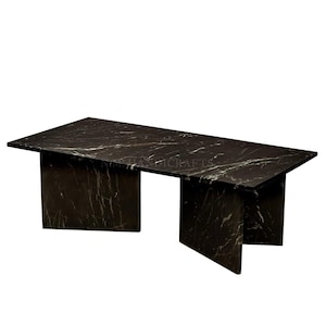 Puede incluir: Una mesa de centro de mármol negro con una tapa rectangular y cuatro patas. La mesa tiene un diseño único con las patas que se extienden desde los lados de la tapa.