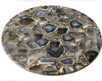 May include: Round agate table top with a natural pattern of gray, brown, and white agate slices. The table top is made of polished agate and has a smooth, glossy finish.