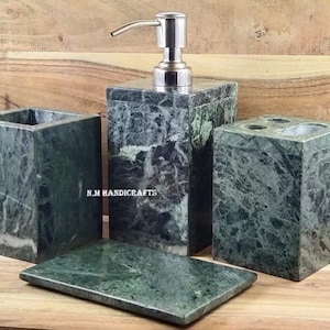 Puede incluir: Conjunto de baño de mármol verde con dispensador de jabón, portacepillos de dientes, vaso y jabonera. El conjunto está hecho de mármol verde con vetas blancas. El dispensador de jabón tiene una bomba plateada.