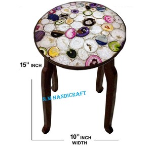 May include: A round decorative stool with a top made of colorful agate slices. The stool has dark brown curved legs and measures 15 inches in diameter and 10 inches wide.