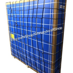 May include: A large cardboard box with a blue and white grid pattern is secured with a black cargo net. The box is labelled with the text "Etsy.com/Shop/NmHandicraftshop".