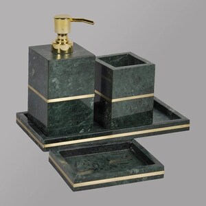 Pode incluir: Conjunto de banheiro de mármore verde com detalhes dourados. O conjunto inclui um dispensador de sabonete, um porta-escovas de dentes e um saboneteira. Todas as peças estão em uma bandeja de mármore combinando.