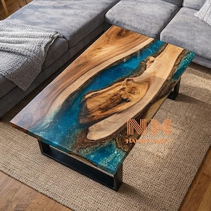 May include: A rectangular coffee table featuring a natural wood slab with a prominent live edge and a central river-like inlay of translucent blue epoxy resin. The table is supported by a black metal frame and displays the text NM.