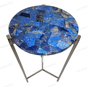 May include: A round side table with a lapis lazuli mosaic top and a silver metal base. The table has a modern design and is perfect for a living room or bedroom.