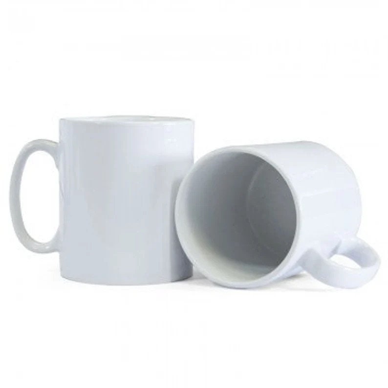 May include: Two white ceramic mugs with handles. The mugs are empty and ready to be filled with a hot beverage.