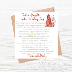 May include: A wedding card with a red and gold design featuring a bride in a traditional Indian outfit. The card reads "To Our Daughter on her Wedding Day" and includes a message from the bride's parents wishing her well on her special day.