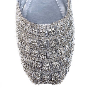 Puede incluir: Un zapato plano plateado con un dise&ntilde;o brillante de tipo cristal que cubre toda la parte superior del zapato.