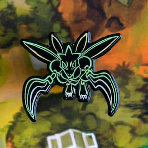 May include: Black and green enamel pin featuring a cartoon creature with sharp claws and glowing green eyes.
