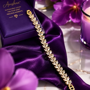 Areshna™ The Aurora 18K gold-plated crystal tennis bracelet crafted with Swarovski elements and Diamonash™ lab-created diamond simulants, showcased next to the brand's signature royal purple presentation box.