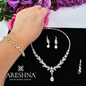 The Aurora bridal set by Areshna™, including necklace, earrings, and bracelet in 18K gold with shimmering Swarovski crystals, elegant and timeless.