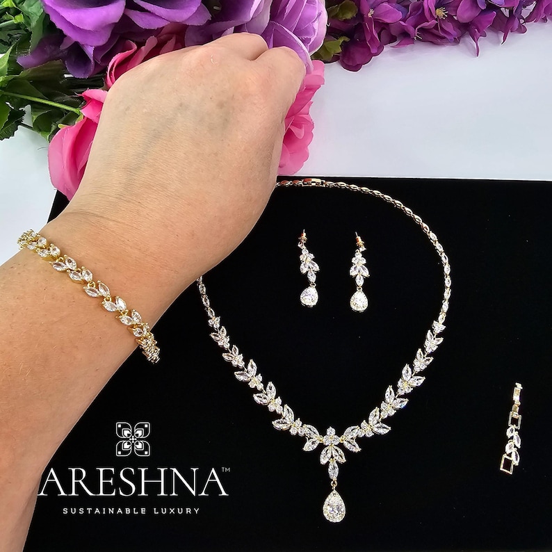 The Aurora bridal set by Areshna™, including necklace, earrings, and bracelet in 18K gold with shimmering Swarovski crystals, elegant and timeless.