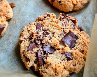 Puede incluir: Primer plano de una bandeja para hornear con una variedad de galletas con chispas de chocolate. Algunas galletas tienen chispas de chocolate grandes, mientras que otras tienen chispas de chocolate más pequeñas. Las galletas son de color marrón dorado y parecen estar recién horneadas.