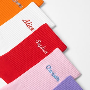 A selection of ladies socks embroidered with custom names in different colour threads on many vibrant ribbed knit socks