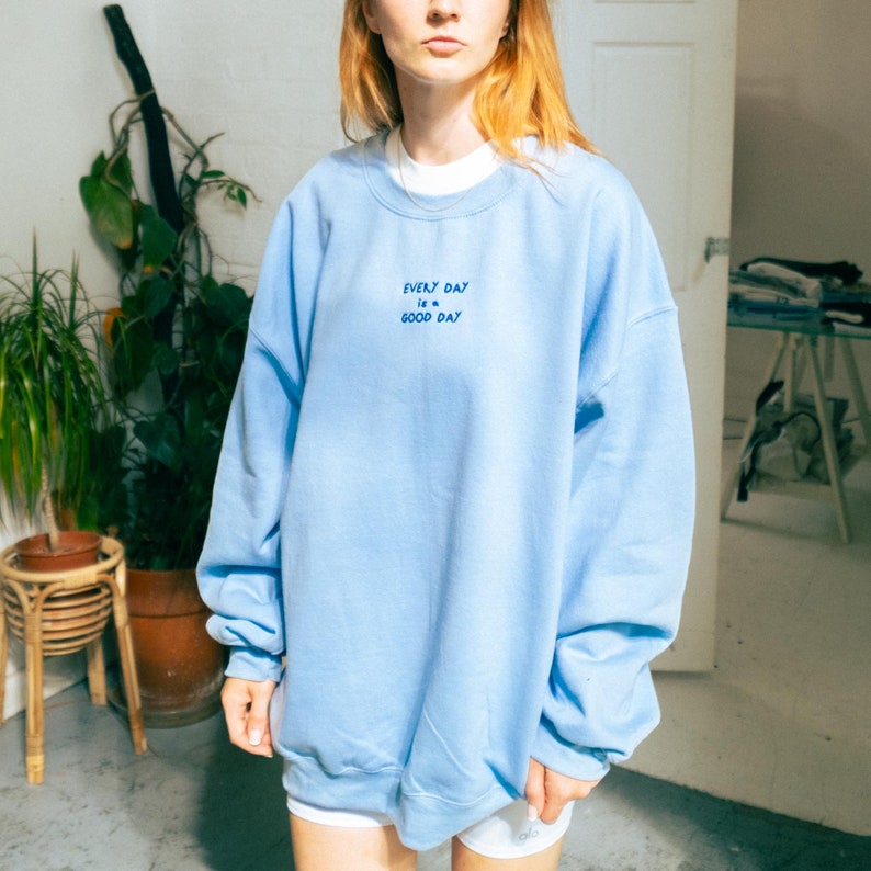 A girl wearing oversized unisex sweater at home