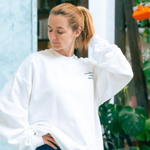 Woman wearing oversized white sweatshirt with custom personalised embroidery in black