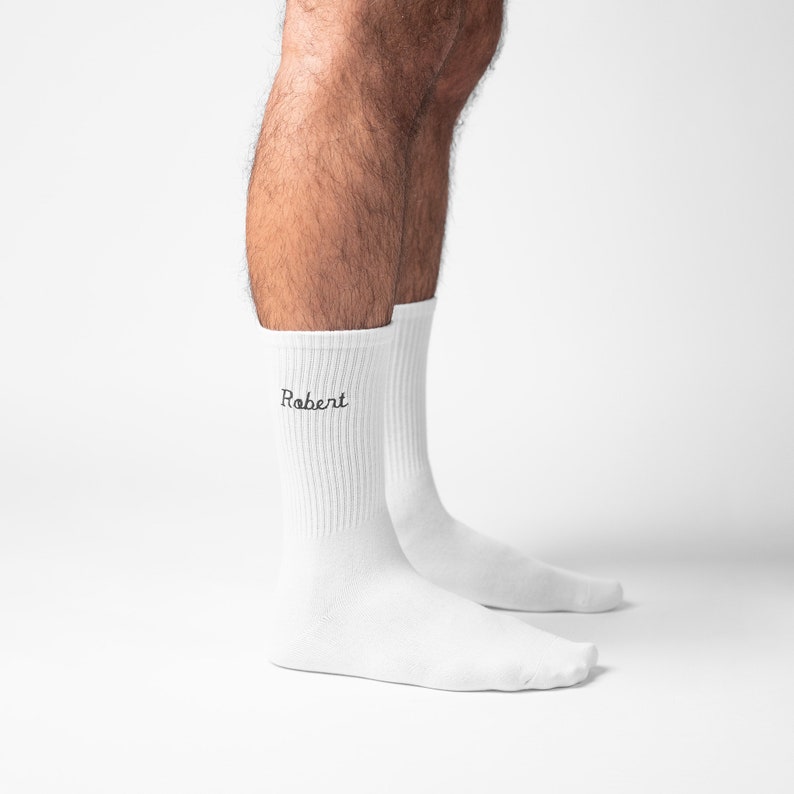 Man ankle with white socks and custom embroidery on them featuring male name Robert