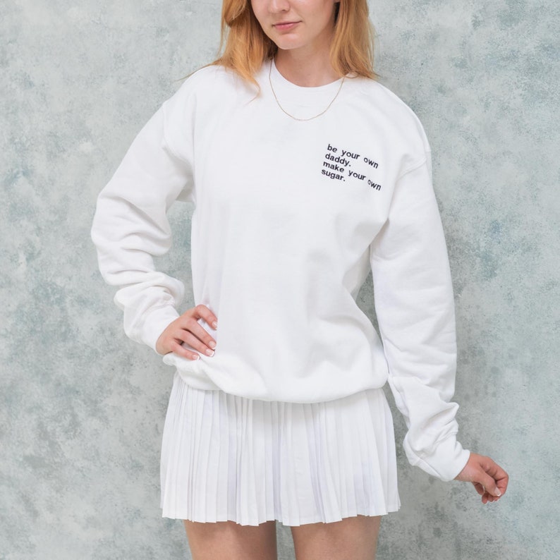 Unisex oversized white jumper with custom text embroidered on her chest