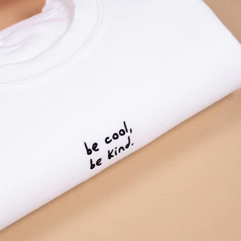White unisex sweatshirt in white colour with inspirational be cool be kind quote